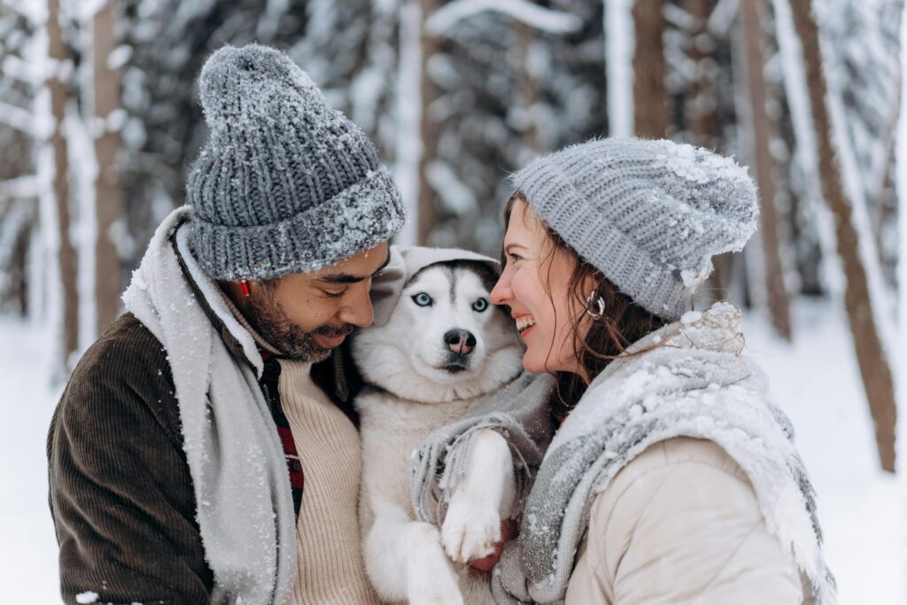 couple-with-husky-in-snow